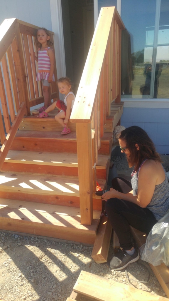 two girls on deck that a woman is working on