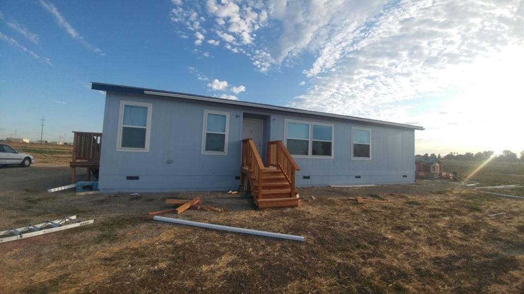 A home in the country with most of its vinyl gutters on