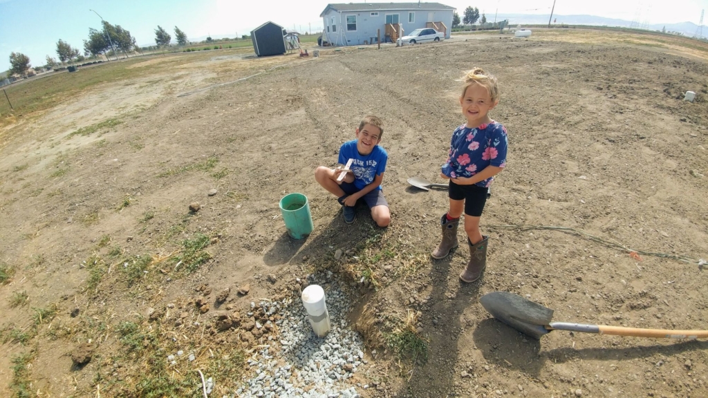 two children near a monitoring well for a septic system