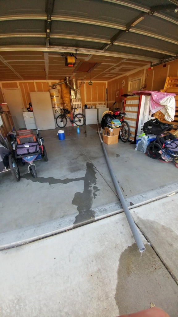 pipe coming from a washer through a garage to drain