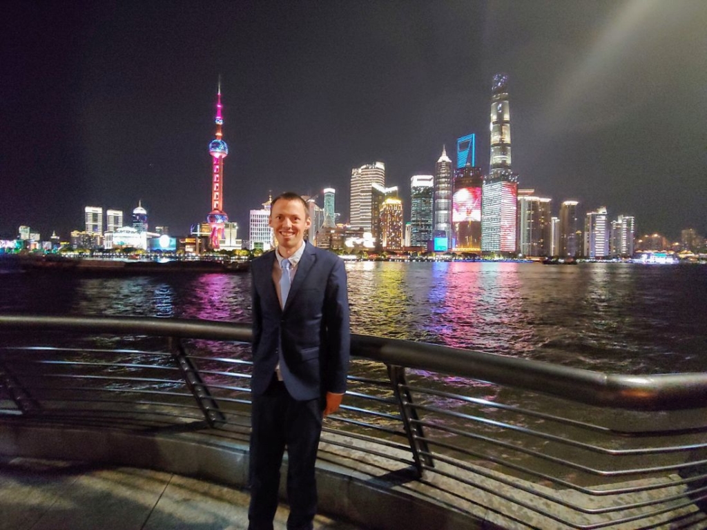 Man standing near the lights of Shanghai city at night