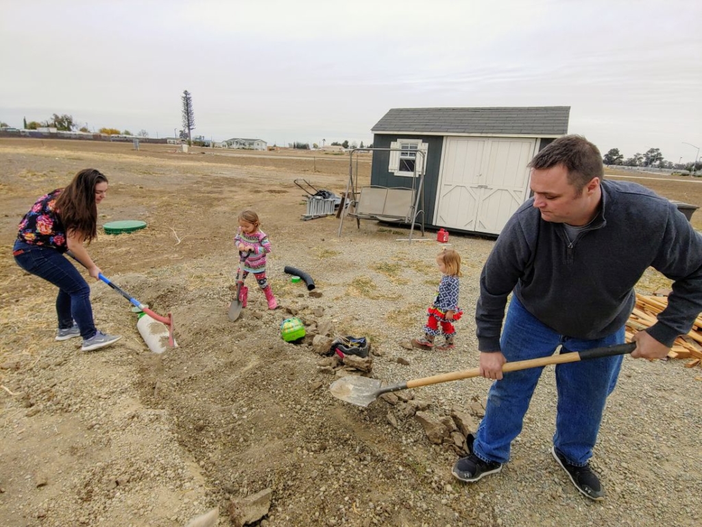 family helping bury pipe