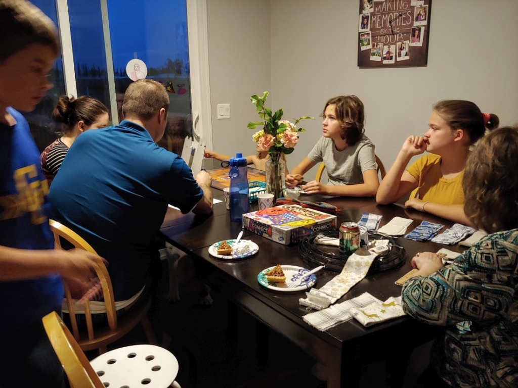 a family sitting down to pie and games